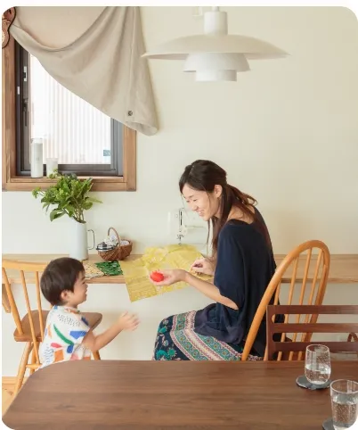 食堂のテーブルに座っている女性と子供の画像。穏やかな雰囲気が漂うシーンです。