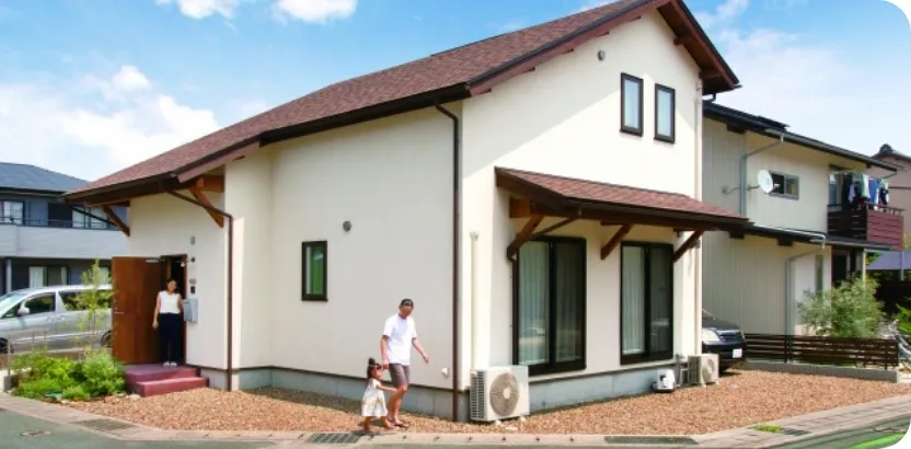 家の外に立っている家族の姿。笑顔で団らんを楽しむ温かい雰囲気が伝わる。