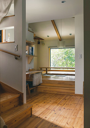 玄関からリビング、窓越しの青々とした緑を眺める