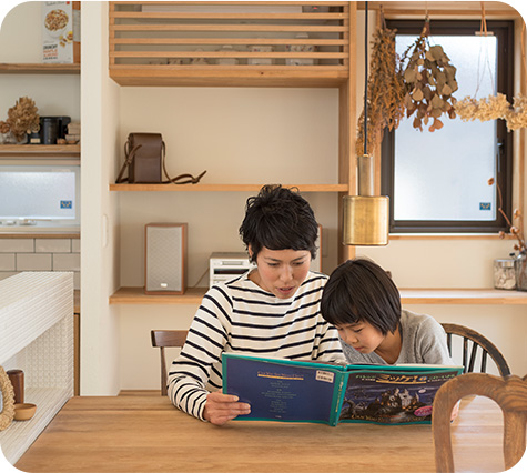 女性と子供がテーブルに座っている様子を描いた画像です。