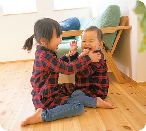 二人の小さな女の子が床に座っている様子を描写した画像です。