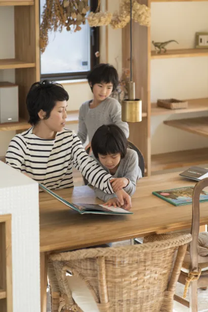 子どもたちに本を読み聞かせている母親