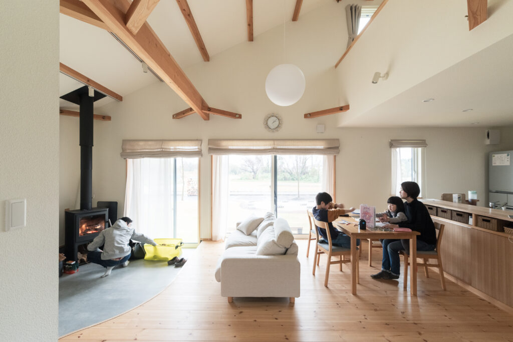 吹き抜けと大開口を通して広がる、空と緑と家族の息づかい